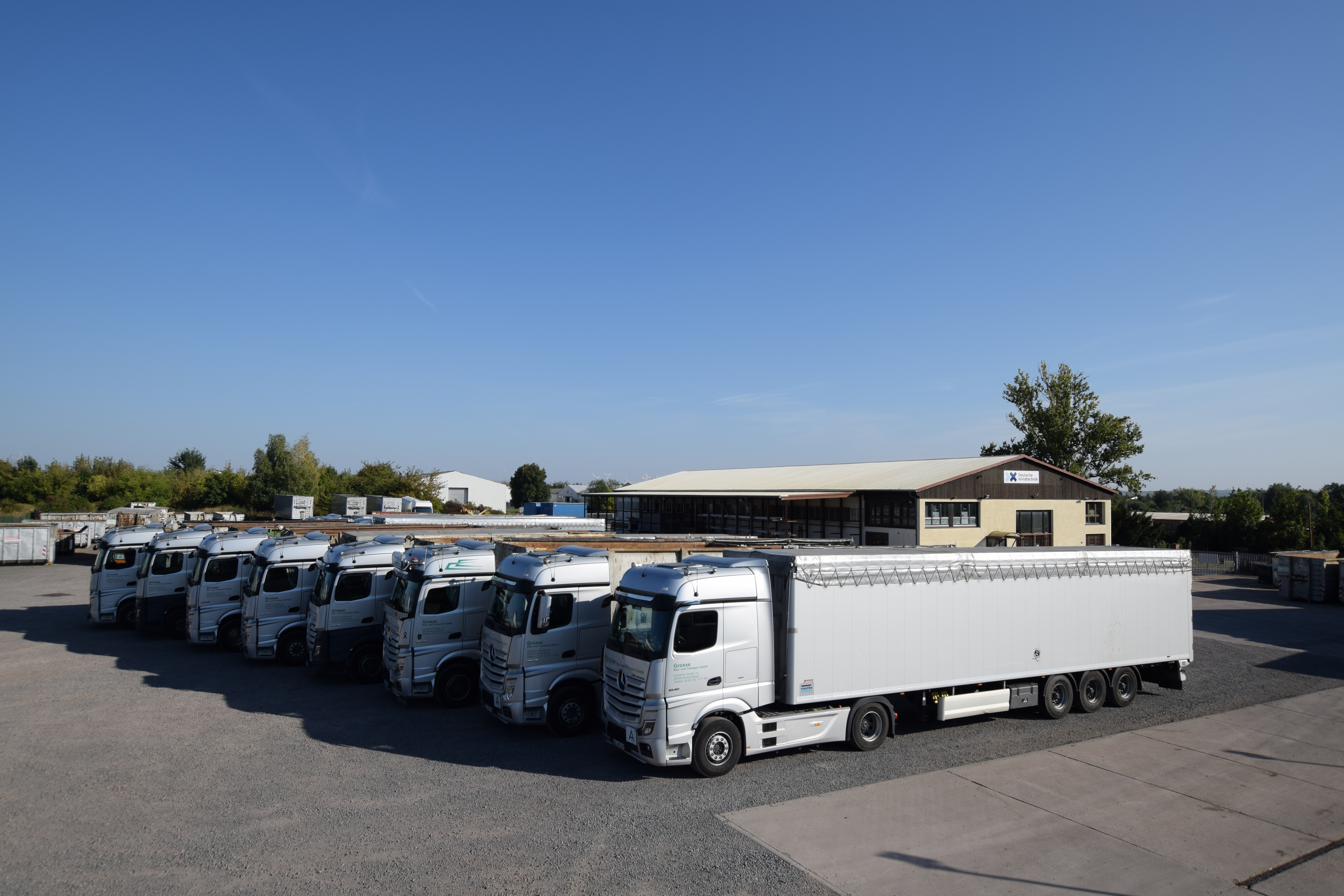 gesamte Flotte im Vordergrund ein Sattelzug 
            mit Schubbodenauflieger 